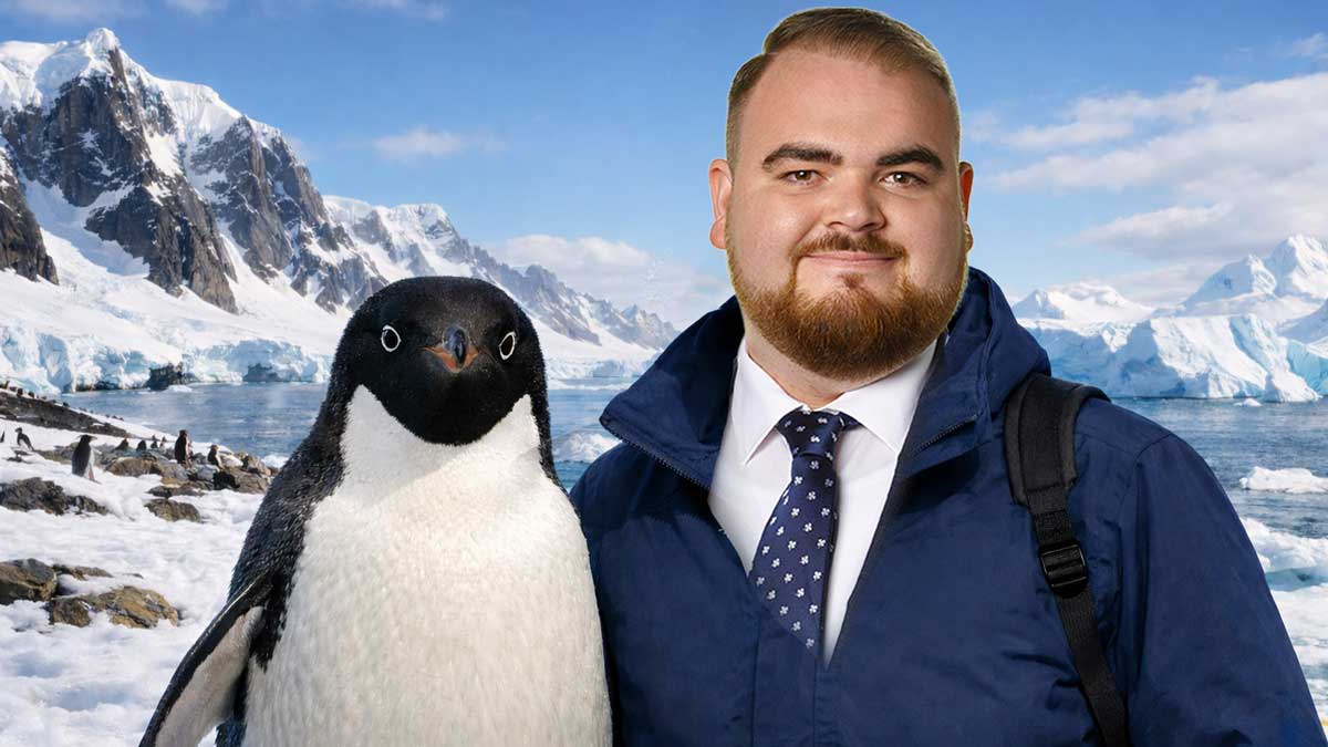 Bailey Wollenweber im blauem Anzug mit seinem Freund dem Pinguin